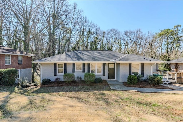 single story home featuring a front yard and brick siding