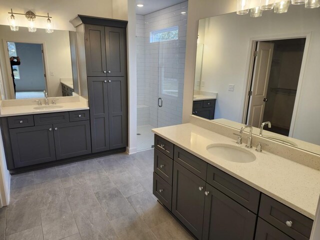 bathroom featuring tile patterned flooring, vanity, and a shower with shower door