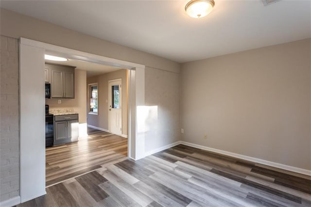 empty room with dark wood-style floors and baseboards