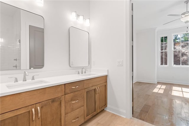 bathroom with double vanity, ceiling fan, a sink, and wood finished floors