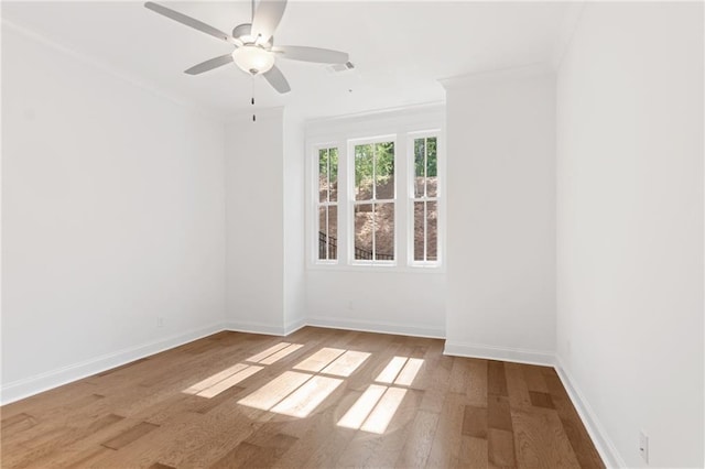 unfurnished room with visible vents, crown molding, baseboards, and wood finished floors