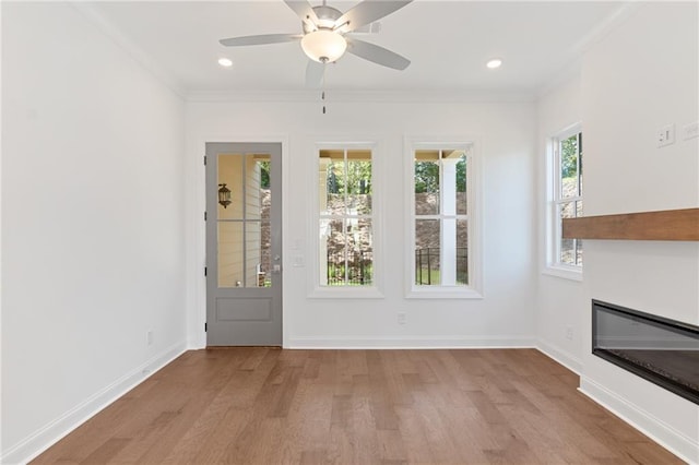 doorway to outside with baseboards, crown molding, and light wood-style floors