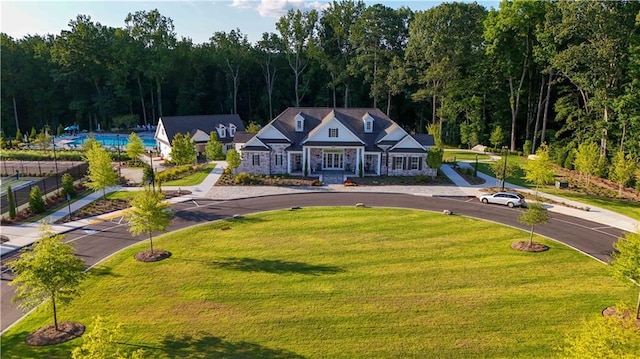 view of front facade with a forest view and a front lawn