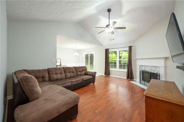 5279 Leecroft Dr, Buford, GA 30518 - living area with a high end fireplace, ceiling fan, wood finished floors, vaulted ceiling, and a chandelier