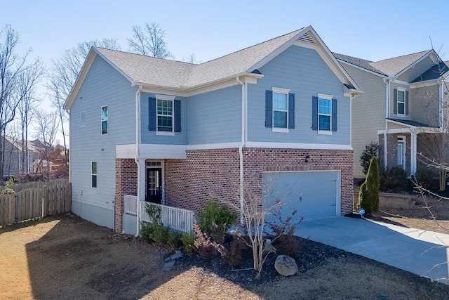 traditional home with concrete driveway, roof with shingles, an attached garage, fence, and brick siding