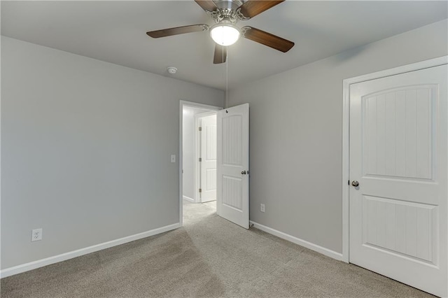 carpeted spare room with ceiling fan