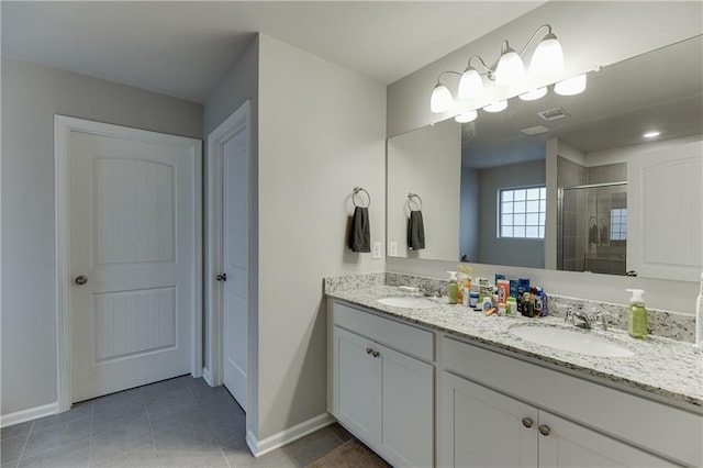 bathroom with tile patterned floors, a shower with door, and vanity