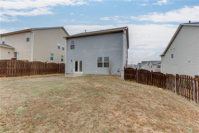 rear view of property featuring a lawn