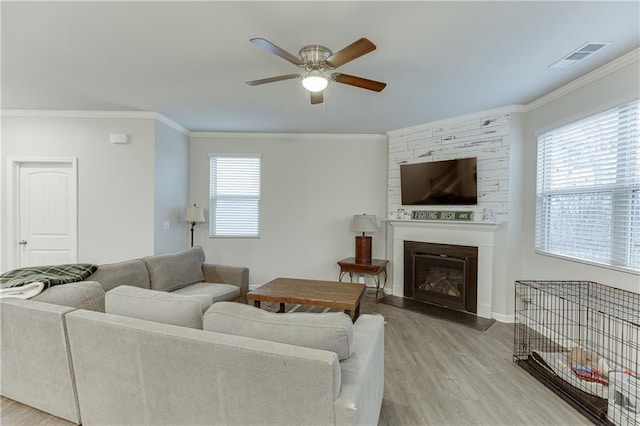 living room with crown molding, ceiling fan, and light hardwood / wood-style flooring