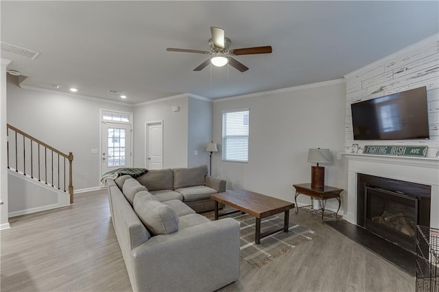 living room featuring crown molding, ceiling fan, plenty of natural light, and light wood-type flooring