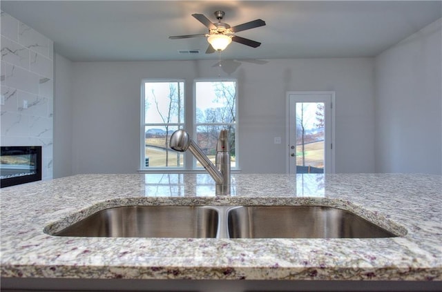 115 Greenview Ct, Homer, GA 30547 - kitchen view of light stone counters, ceiling fan, and a fireplace