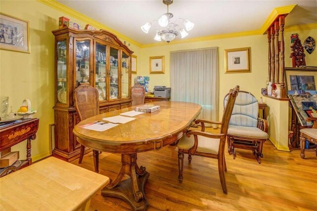 dining space with ornamental molding, hardwood / wood-style flooring, and a chandelier