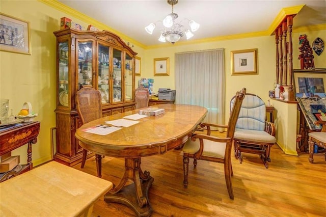 dining area featuring a chandelier, ornamental molding, and light wood-type flooring