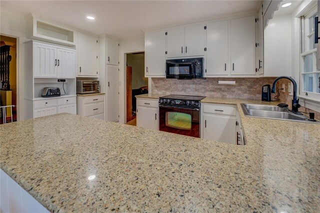 500 Cochran Rd, Covington, GA 30014 - kitchen featuring black appliances, a sink, white cabinetry, tasteful backsplash, and light stone counters