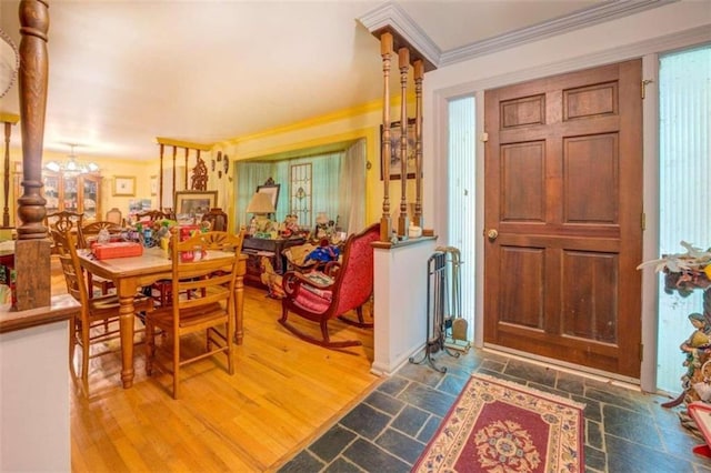 foyer entrance with crown molding, hardwood / wood-style flooring, and a chandelier