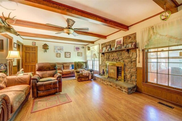 living room with beamed ceiling, hardwood / wood-style flooring, a fireplace, and ceiling fan