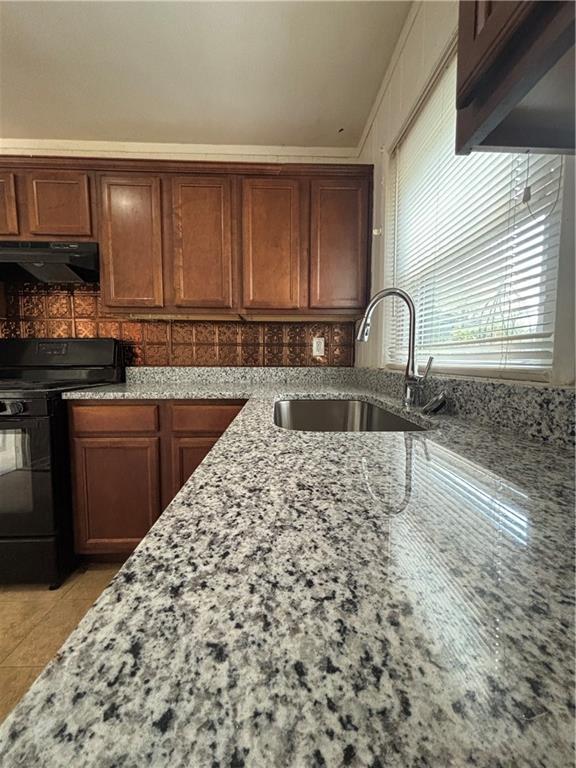 2069 Bixler Cir, Decatur, GA 30032 - kitchen featuring black range with gas cooktop, backsplash, a sink, light stone counters, and under cabinet range hood