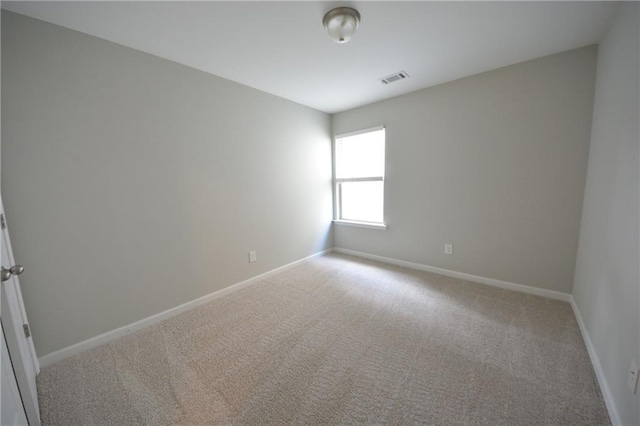 spare room featuring light colored carpet