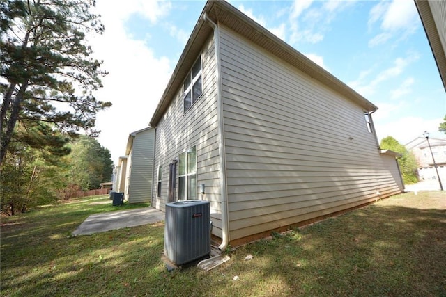 view of home's exterior featuring a patio, central AC unit, and a lawn