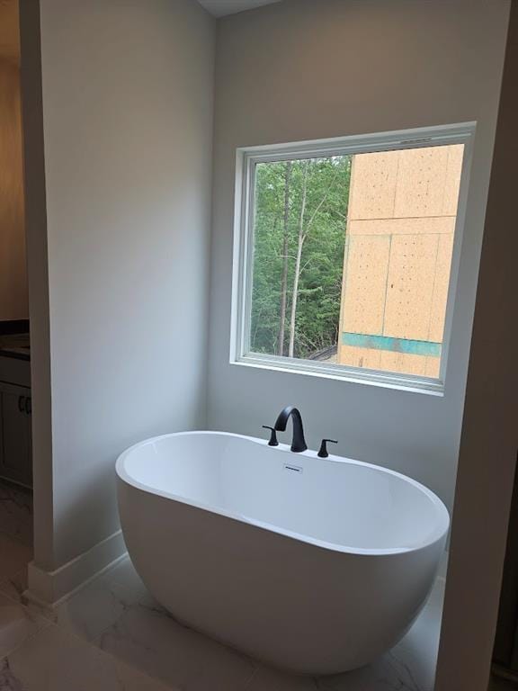 195 Silvercrest Dr, Acworth, GA 30101 - bathroom featuring marble finish flooring, a soaking tub, and baseboards