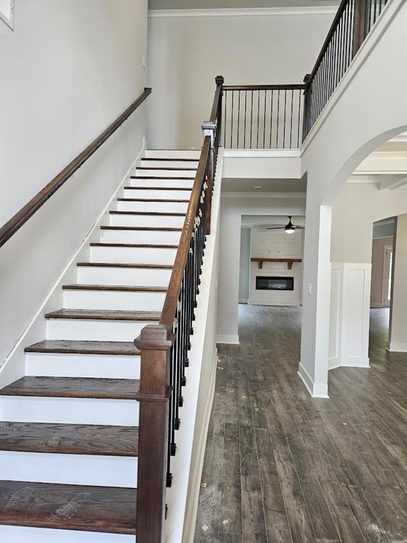195 Silvercrest Dr, Acworth, GA 30101 - stairs featuring a high ceiling, ceiling fan, wood finished floors, arched walkways, and baseboards