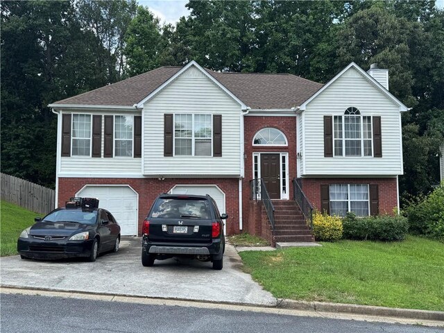4192 Rhinehart Dr, Austell, GA 30106 - raised ranch with concrete driveway, a garage, brick siding, a chimney, and roof with shingles