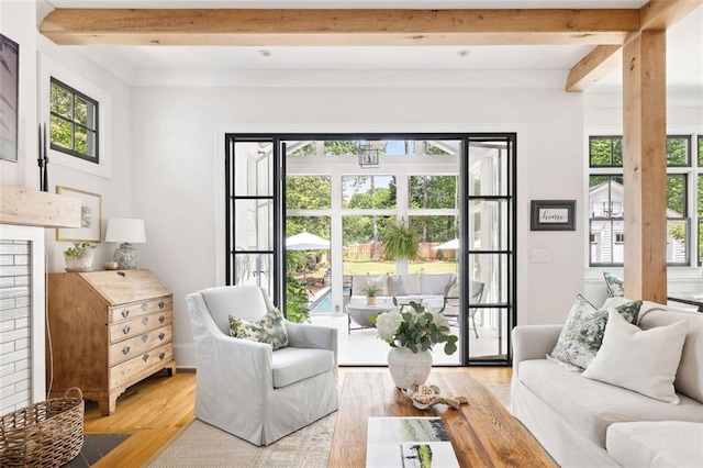 living room with beamed ceiling and light wood-style floors