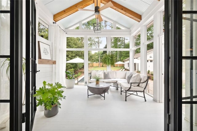 sunroom / solarium featuring lofted ceiling with beams, expansive windows, and wood finished floors