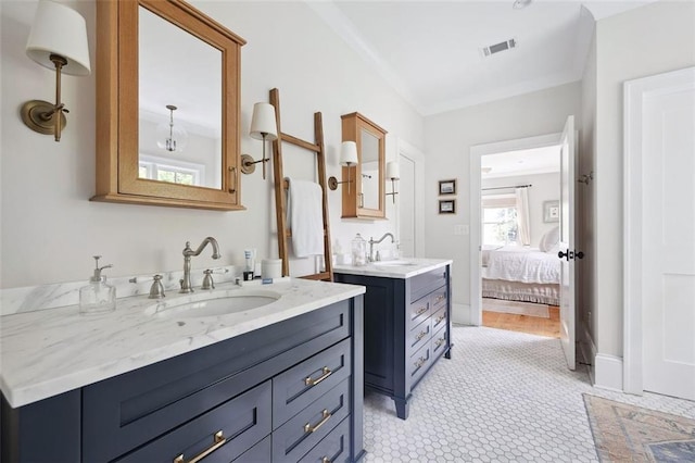 bathroom featuring visible vents, a sink, crown molding, and two vanities