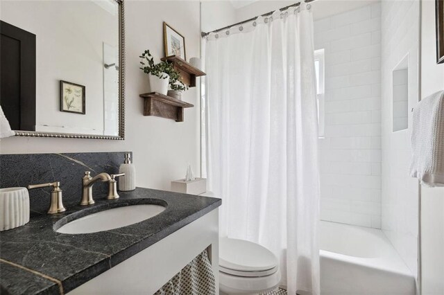 full bathroom featuring vanity, shower / tub combo with curtain, toilet, and tasteful backsplash