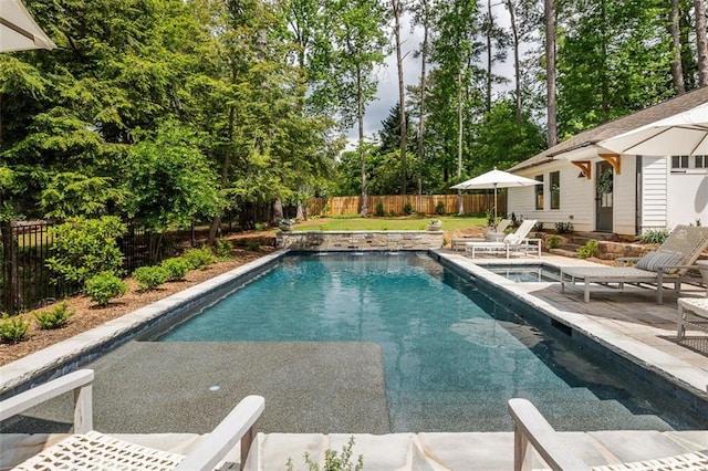 view of pool featuring a patio, a fenced in pool, an outbuilding, and a fenced backyard