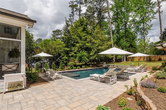 outdoor pool with fence and a patio