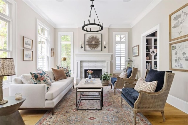 living area with crown molding, wood finished floors, and a fireplace