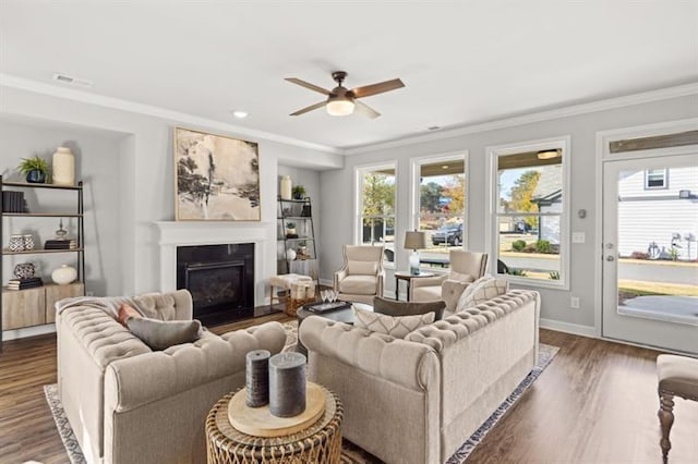 living room with dark hardwood / wood-style flooring, ornamental molding, and ceiling fan