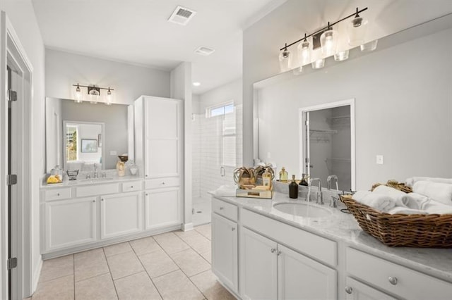 bathroom featuring tile patterned flooring, vanity, and a shower