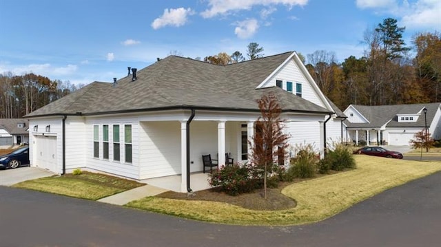 view of home's exterior featuring a garage, a porch, and a lawn