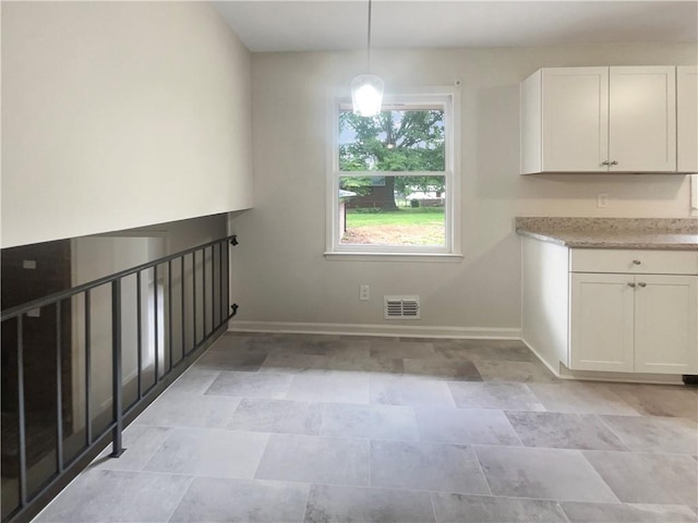 1710 Fontaine Dr, Jonesboro, GA 30236 - unfurnished dining area with baseboards and stone finish floors