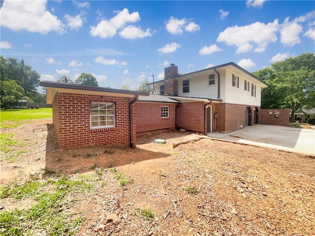 1710 Fontaine Dr, Jonesboro, GA 30236 - back of house with a chimney, brick siding, a garage, and concrete driveway