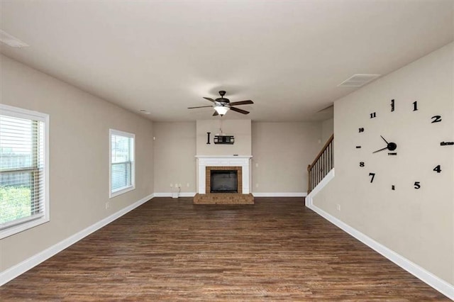 2375 Walker Dr, Hampton, GA 30228 - unfurnished living room with baseboards, a ceiling fan, a brick fireplace, and dark wood-style floors