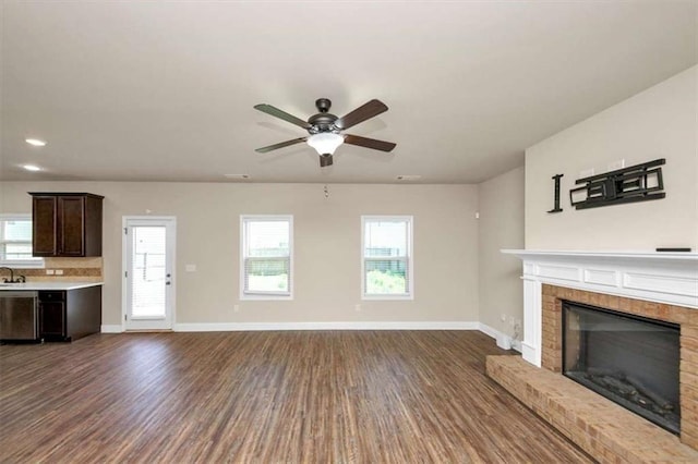 2375 Walker Dr, Hampton, GA 30228 - unfurnished living room featuring a fireplace, dark wood-style flooring, baseboards, and ceiling fan