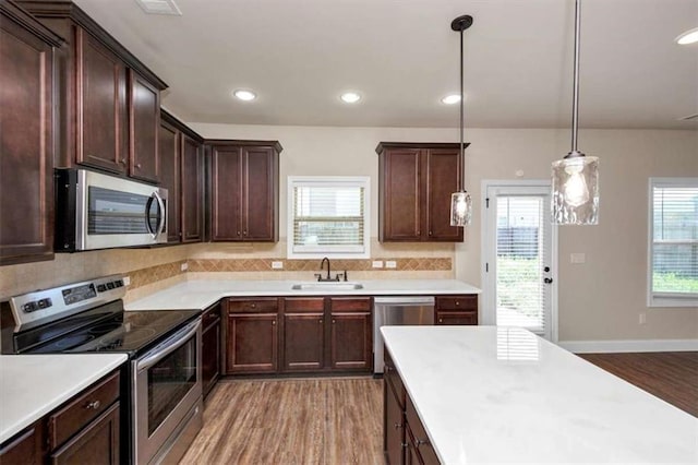 2375 Walker Dr, Hampton, GA 30228 - kitchen with light wood-type flooring, light countertops, a healthy amount of sunlight, stainless steel appliances, and a sink
