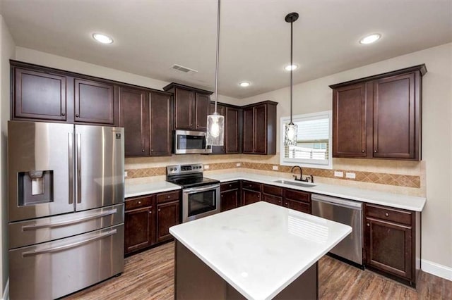 2375 Walker Dr, Hampton, GA 30228 - kitchen with dark brown cabinetry, visible vents, stainless steel appliances, a sink, and wood finished floors