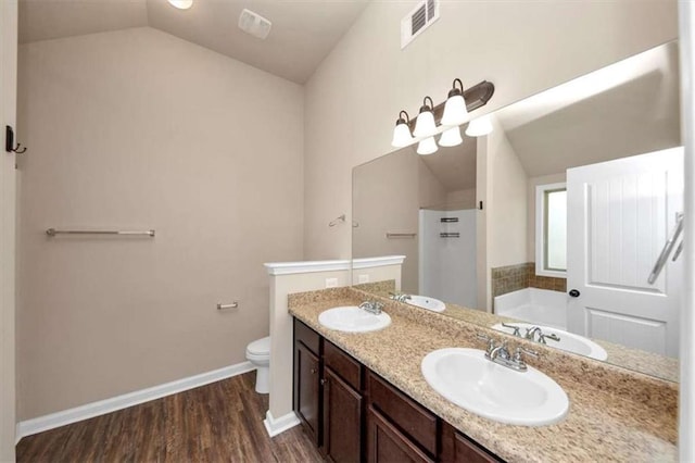 2375 Walker Dr, Hampton, GA 30228 - bathroom with wood finished floors, a bath, a sink, and lofted ceiling
