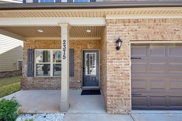 2375 Walker Dr, Hampton, GA 30228 - entrance to property featuring an attached garage, covered porch, and brick siding