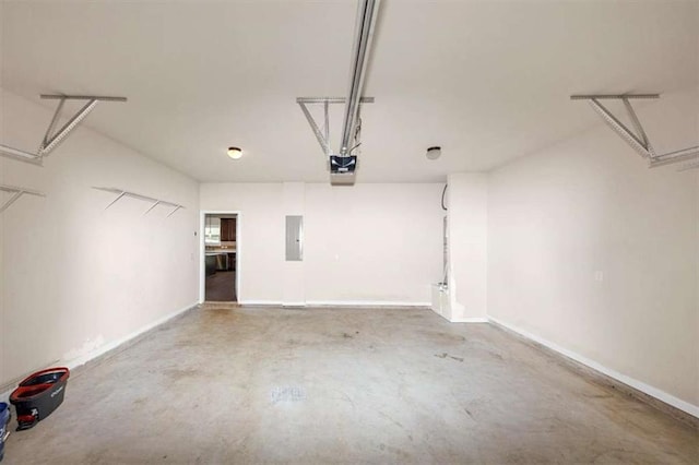 2375 Walker Dr, Hampton, GA 30228 - garage featuring baseboards, a garage door opener, and electric panel