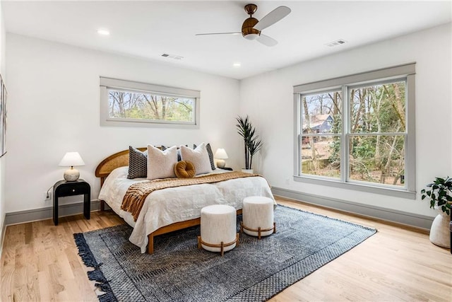 bedroom with wood finished floors, visible vents, and multiple windows