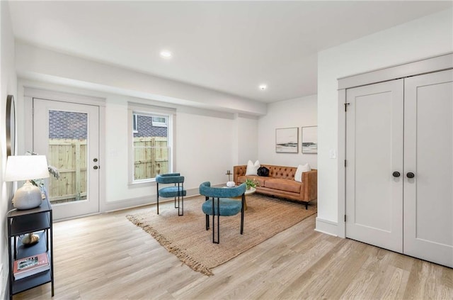 living area with baseboards, recessed lighting, and light wood-style floors