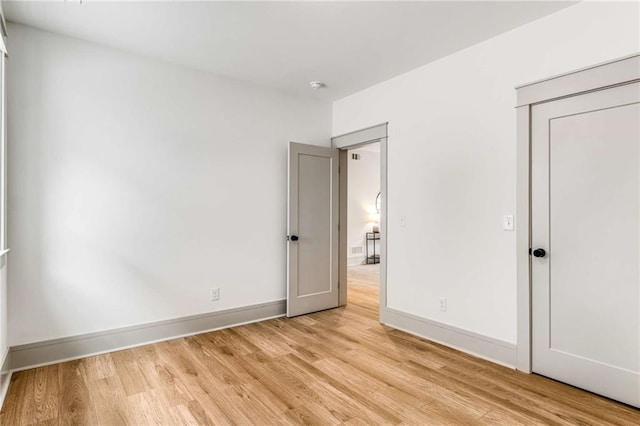 unfurnished bedroom featuring light wood-type flooring and baseboards