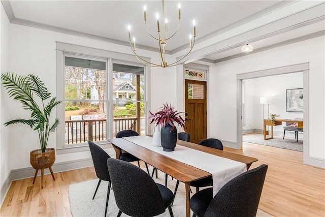 dining room with light wood finished floors, baseboards, crown molding, and an inviting chandelier