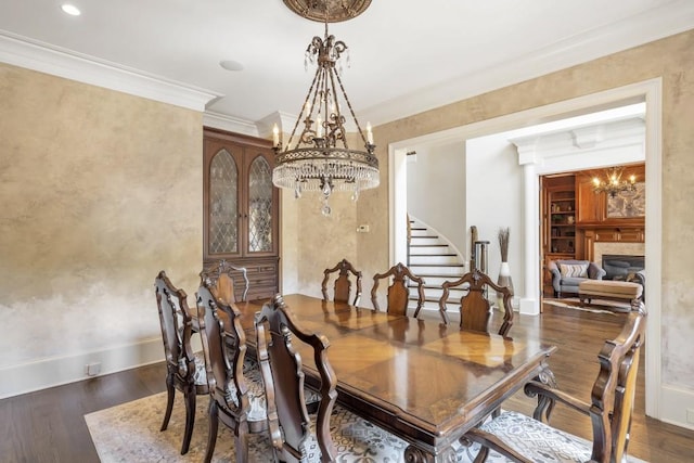 4317 Oglethorpe Loop NW, Acworth, GA 30101 - dining space featuring a chandelier, stairs, wood finished floors, ornamental molding, and a fireplace